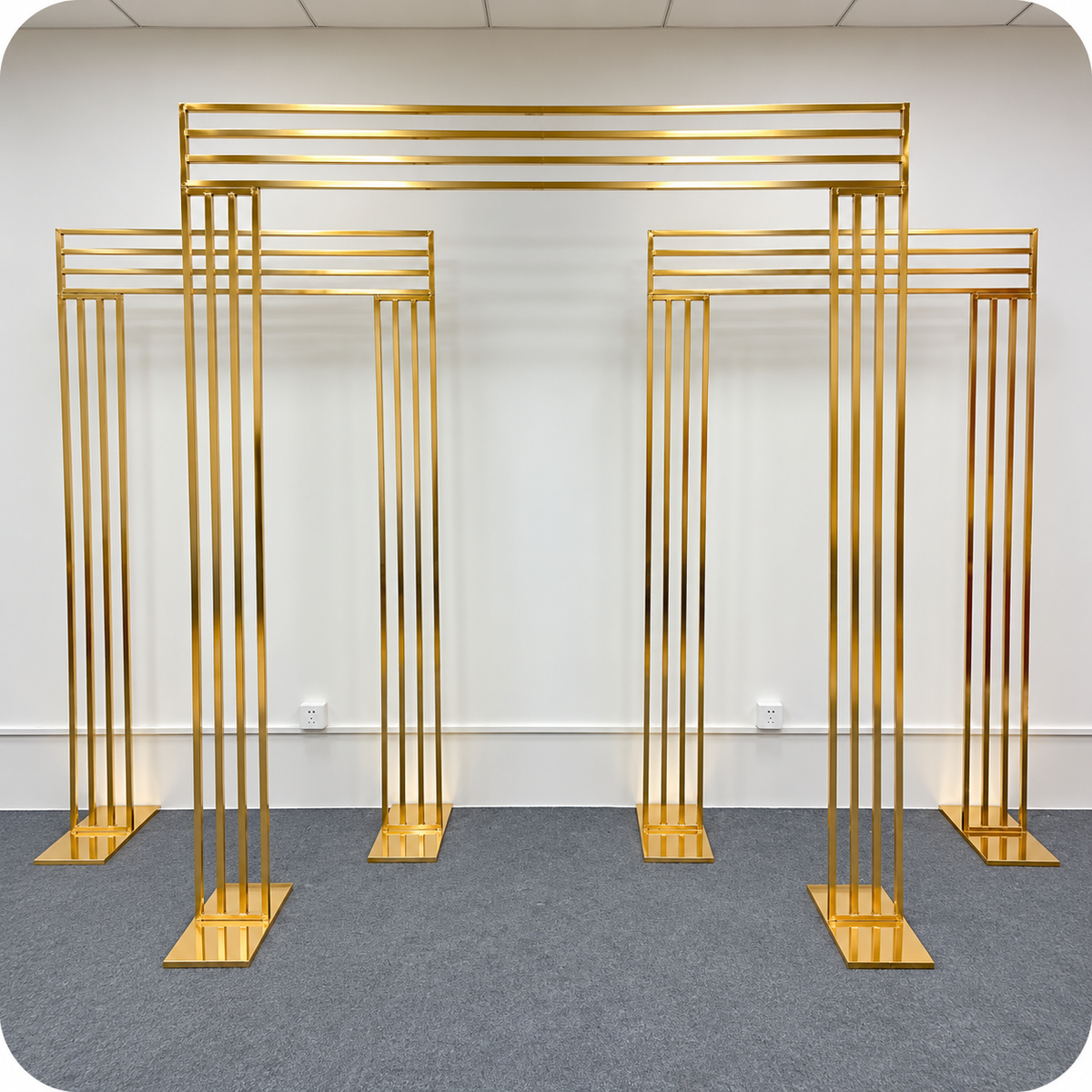 Three-piece gold metal wedding arch backdrop set featuring one large centre arch and two smaller matching rectangular arches for wedding and event rentals in Ottawa.